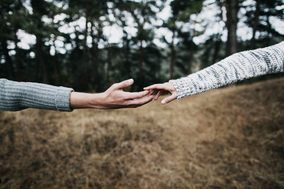 two hands reaching for each other outside